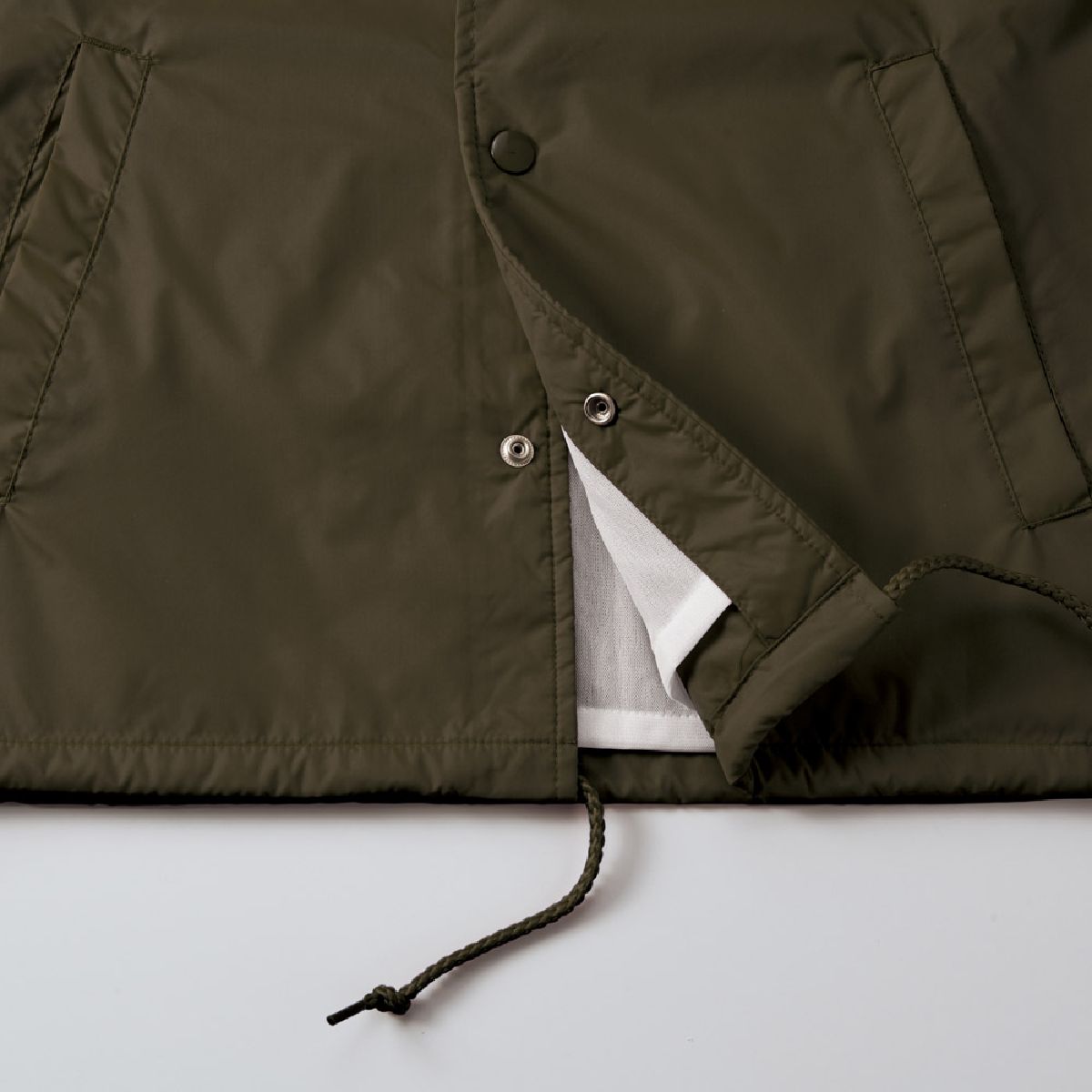 Features a drawstring (round cord) to adjust for wind intrusion and prevent the garment from flapping.